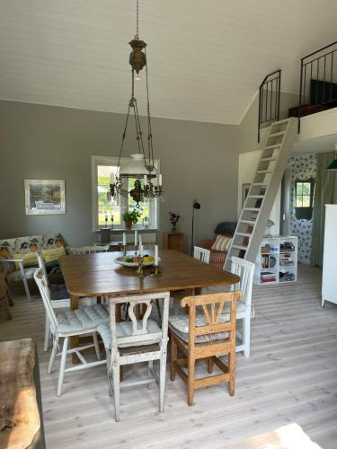 a dining room with a wooden table and chairs at Idyllically nice house on Bjärehalvön, Torekov! in Båstad