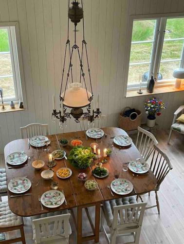 a dining room table with plates of food and candles at Idyllically nice house on Bjärehalvön, Torekov! in Båstad