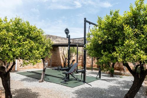 a swing set in a garden with trees at Masseria Borgo San Marco in Fasano