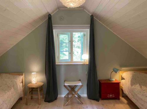 a attic room with a window and two beds at Idyllically nice house on Bjärehalvön, Torekov! in Båstad