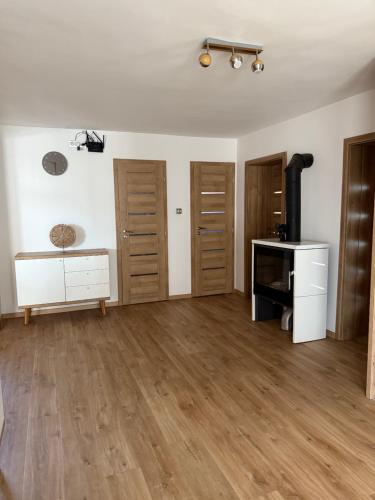 an empty living room with wooden floors and a television at Dom pod hradom s kinom a saunou 