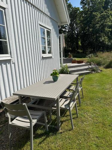 a picnic table and chairs outside of a house at Idyllically nice house on Bjärehalvön, Torekov! in Båstad