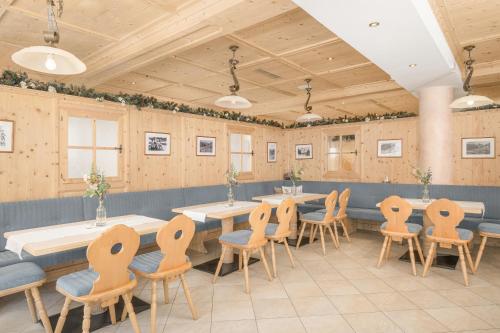 a restaurant with tables and chairs in a room at Alpenhotel Tirolerhof Gerlos in Gerlos