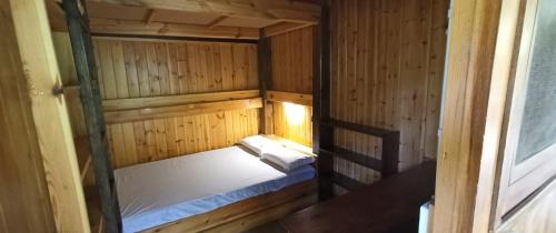 a small wooden cabin with a bed in it at Camping Collegats in La Pobla de Segur