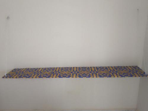 a shelf in a room with a white wall at Rejoice in Serekunda