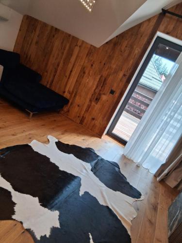 a room with a cow rug on a wooden floor at Monterai Resort in Poiana Brasov