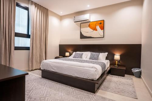 a bedroom with a large bed and a window at الرابية - شقق فارهة - دخـول ذكي in Abha