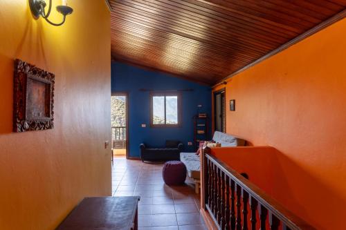 a living room with blue walls and a wooden ceiling at Casa Amarilla de Playa Benijo in Almáciga