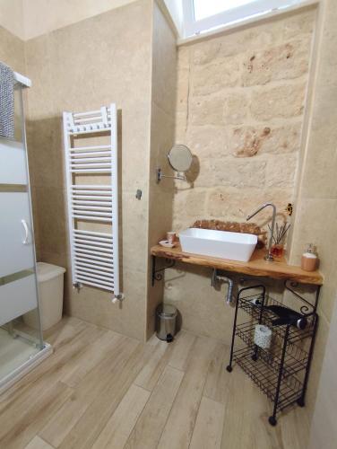a bathroom with a sink on a wooden table at Casa vacanze LU FUMARU in Nardò