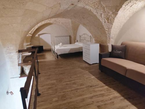 a bedroom with two beds and a couch in a room at Casa vacanze LU FUMARU in Nardò