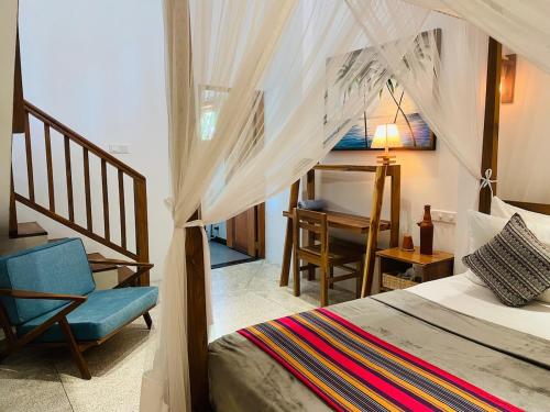 sypialnia z łóżkiem, krzesłem i biurkiem w obiekcie Calathea inn unawatuna w mieście Galle