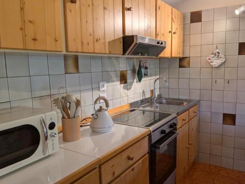a kitchen with a sink and a stove and a microwave at Casetta Scricciolo in Enego