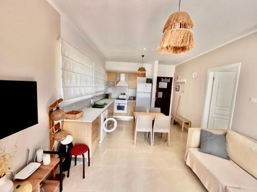 a kitchen and living room with a couch and a table at Boho Beach Apartment in Tatlisu
