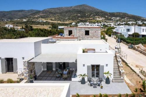 a white house with mountains in the background at Fos Residence Dryos in Drios