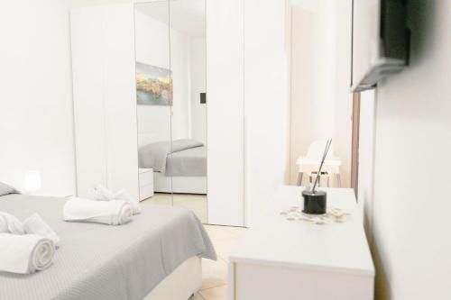 a white room with a bed and a mirror at Levante Eight Appartamento Vista Mare in Bari