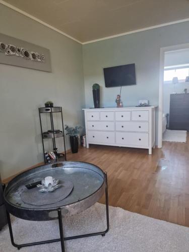 a living room with a glass table and a tv at Cozy apartment Rose in Fjälkinge