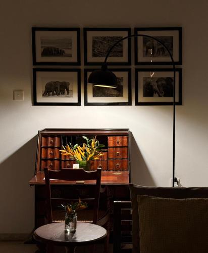a dining room with a table and a lamp and pictures on the wall at Nyne Hotels Mayur Lodge - Yala - All Inclusive in Yala