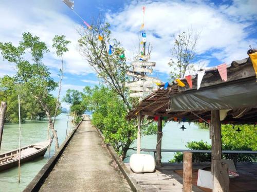 a path next to a river with a boat on it at THE REAL ESCAPE - Koh Yao Noi in Ko Yao Noi