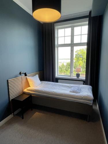 a bedroom with a bed in front of a window at Vandrarhemmet Åmål in Åmål