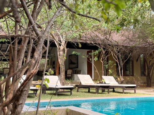 a resort with a swimming pool and two lounge chairs at Nyne Hotels Mayur Lodge - Yala - All Inclusive in Yala