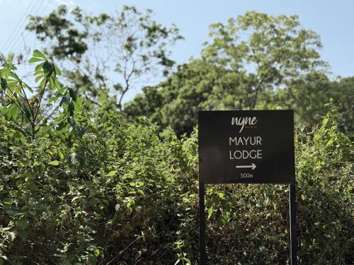 a sign in front of some bushes and trees at Nyne Hotels Mayur Lodge - Yala - All Inclusive in Yala