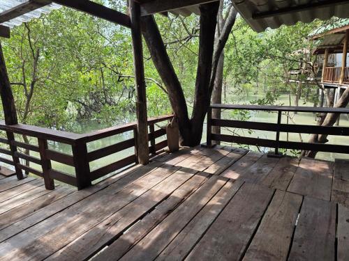a wooden deck with a tree and a fence at THE REAL ESCAPE - Koh Yao Noi in Ko Yao Noi