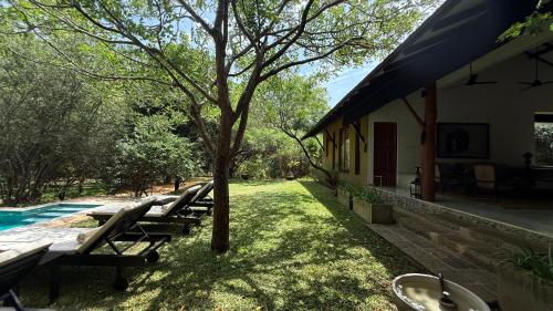 a group of lounge chairs sitting next to a house at Nyne Hotels Mayur Lodge - Yala - All Inclusive in Yala