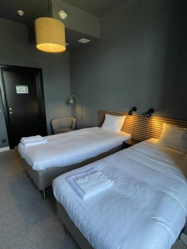a room with two beds and a chair in it at Vandrarhemmet Åmål in Åmål