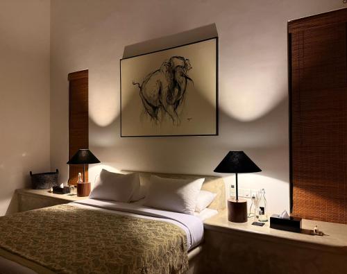 a bedroom with a bed with a drawing on the wall at Nyne Hotels Mayur Lodge - Yala - All Inclusive in Yala