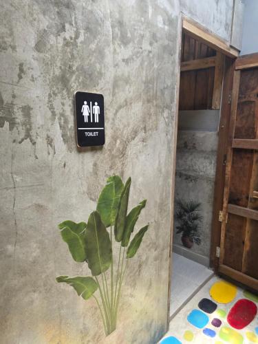 a sign on the side of a wall with a plant at THE REAL ESCAPE - Koh Yao Noi in Ko Yao Noi