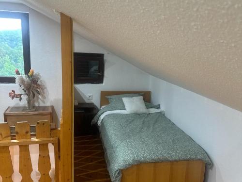a small bedroom with a bed and a window at DATA Bivalni vikend in Gruškovec