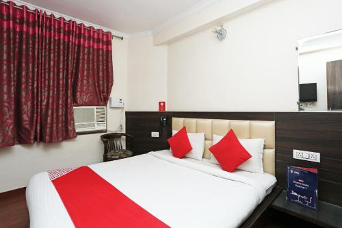 a bedroom with a large bed with red pillows at Hotel O Relax in Gwalior