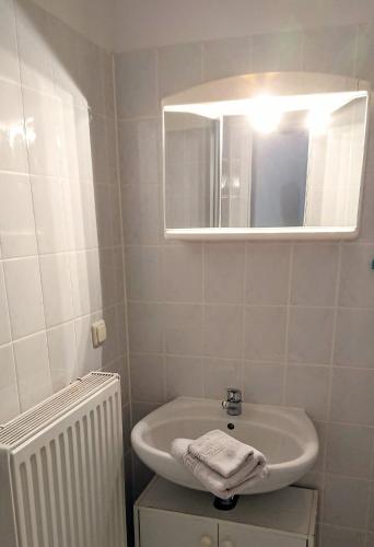 a white bathroom with a sink and a mirror at Pension im Gesundbrunnental in Bad Freienwalde