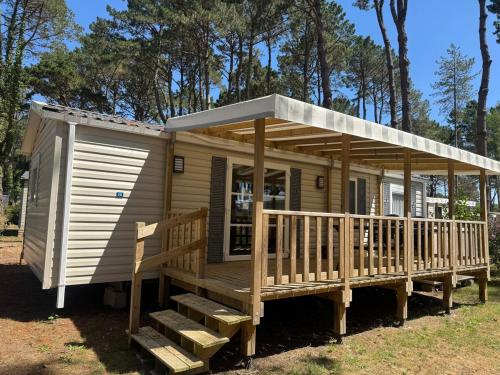 a large wooden cabin with a porch and a deck at Mobil home 6 à 8 personnes in Piriac-sur-Mer
