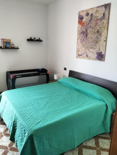 a bedroom with a bed with a green comforter at Da Jack Rooms, la tua casa vacanze! in Penne