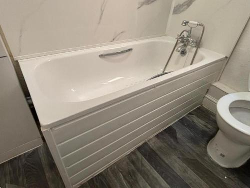 a white bath tub in a bathroom with a toilet at Amazing Studio in London-L in Harrow Weald