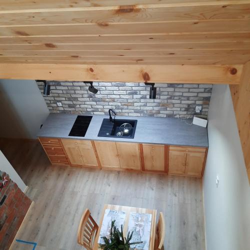an overhead view of a kitchen with a sink and a brick wall at Domek pod Skiełkiem in Łukowica