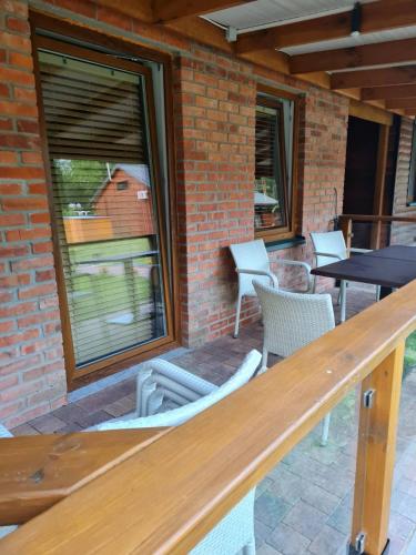 a patio with chairs and a table and windows at Leśna Polana- Kompleks Domków Mieszkalnych in Kamionka