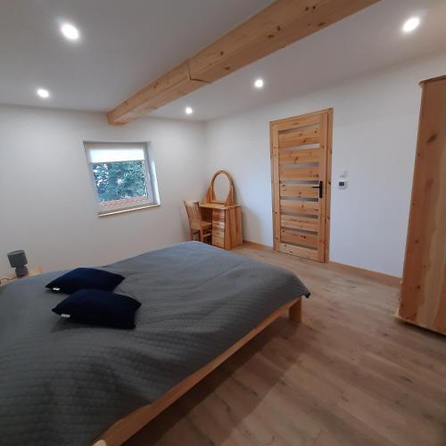 a bedroom with a large bed and a wooden floor at Domek pod Skiełkiem in Łukowica