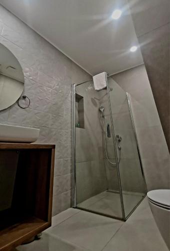 a bathroom with a shower with a sink and a toilet at Hotel Maslina in Seget