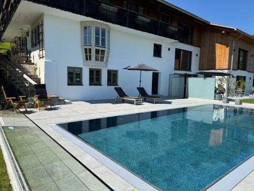 una piscina frente a una casa en Ferienwohnungen mit privater Sauna und traumhaften Salzwasser-Pool, en Anger