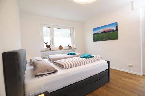 una cama grande en una habitación con ventana en Gemütliche Wohnung in Garmisch nahe Kreuzeck, en Garmisch-Partenkirchen