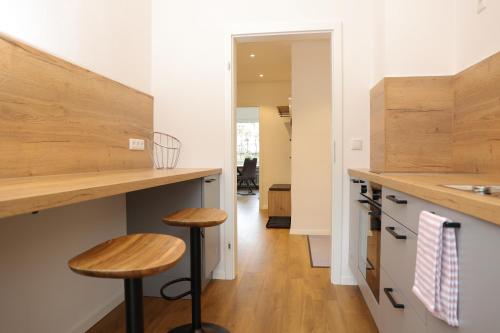 Una cocina con encimeras de madera y dos taburetes. en Gemütliche Wohnung in Garmisch nahe Kreuzeck, en Garmisch-Partenkirchen