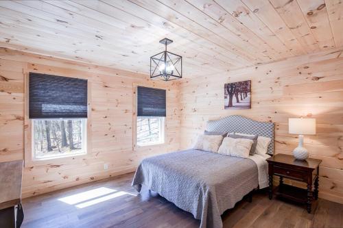 a bedroom with a bed in a wooden cabin at Cozy Cabin near Historic Dahlonega Town Square in Dahlonega