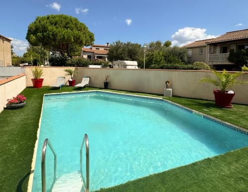 une piscine au milieu d'une cour dans l'établissement Appartement avec piscine et parking privé, à Agde