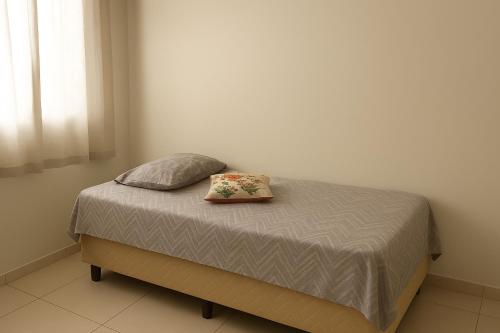 a bed with two pillows on it in a bedroom at Apartamento Cantinho da Cop 30 in Ananindeua