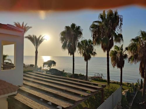 a view of the ocean from a house with palm trees at Beachfront Villa Carpe Diem in Kiti