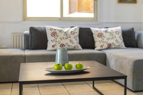 a living room with a couch and a table with three apples at Beachfront Villa Carpe Diem in Kiti