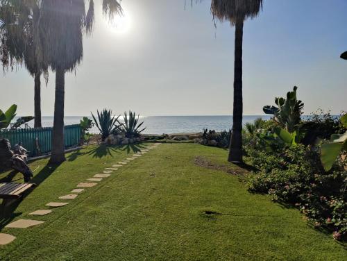 a park with palm trees and the ocean in the background at Beachfront Villa Carpe Diem in Kiti