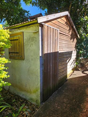a smallshed with a door on the side of it at Ti Palissandre in LʼEntre-Deux